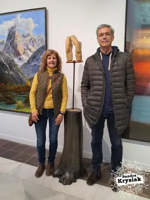 Dos personas junto a una escultura en una exposición