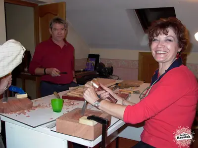 Alumna sonriente tallando en su mesa