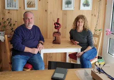 Dos alumnos con una escultura en el banco