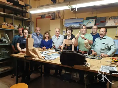 Grupo en el taller con un relieve sobre la mesa