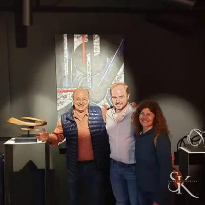 Tres personas junto a una obra expuesta