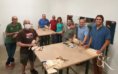Alumnos con sus trabajos alrededor de la mesa
