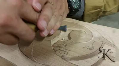 Detalle de manos y gubia sobre un relieve