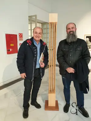 Dos alumnos junto a una escultura expuesta