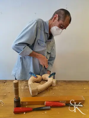Alumno con mascarilla tallando en su mesa