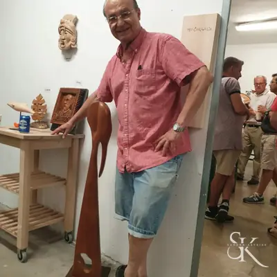 Alumno que muestra una escultura alargada