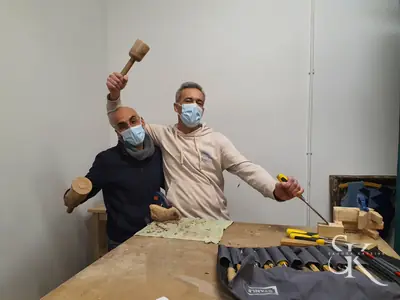 Alumno con mascarilla levanta el mazo sonriente