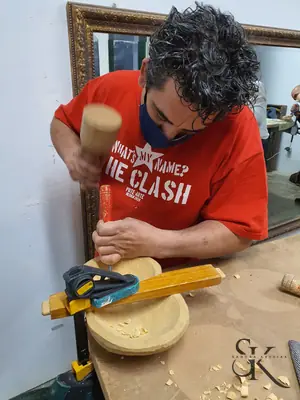 Alumno trabajando un cuenco sujeto al banco