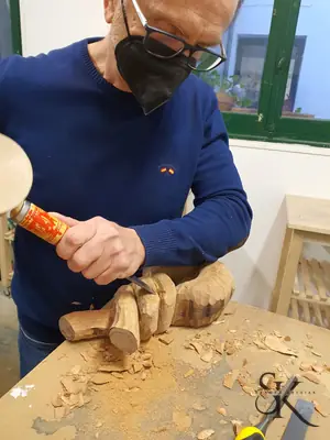 Alumno con mascarilla tallando un relieve