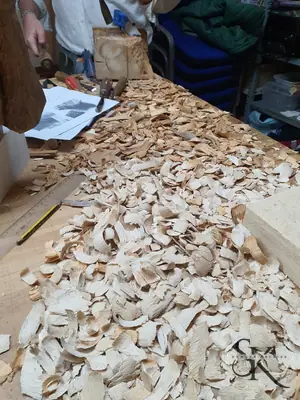 Manos tallando entre abundantes virutas