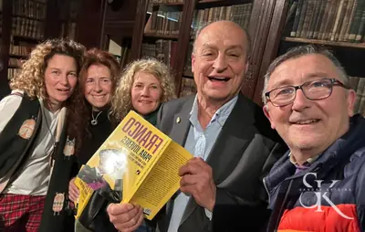 Grupo que posa con un libro en un encuentro