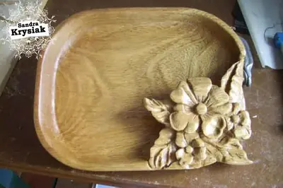 Fuente de madera con flores talladas en una esquina