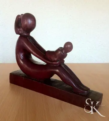 Figura sentada que sostiene otra figura pequeña