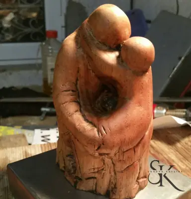 Dos figuras abrazadas talladas en madera