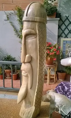 Rostro alargado tallado en un tronco