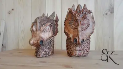 Dos cabezas de criaturas fantásticas talladas