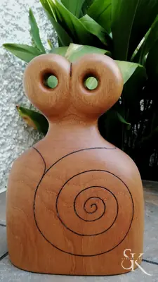 Figura de madera con ojos redondos y espiral