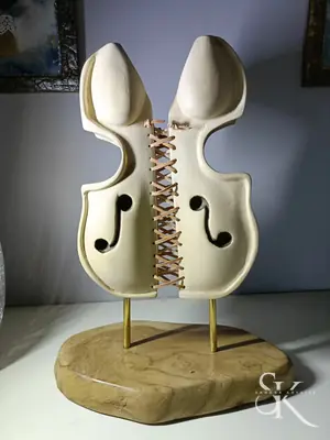 Escultura de dos formas claras sobre varillas