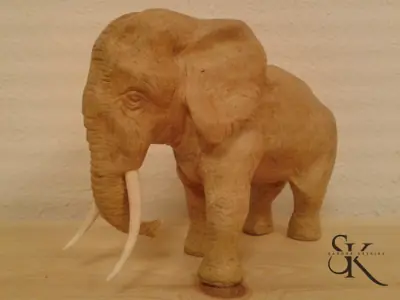 Elefante tallado en madera sobre un fondo neutro