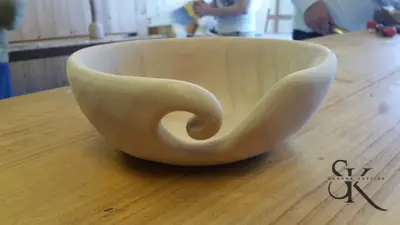Cuenco de madera clara con una forma curva integrada en el borde