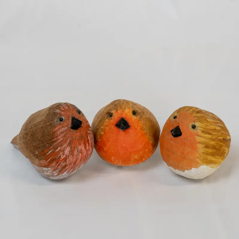 Tres petirrojos tallados en madera y pintados en tonos naranjas y pardos