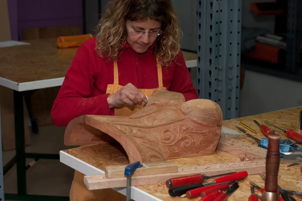 Sandra tallando a mano el detalle del relieve, inclinada sobre la pieza