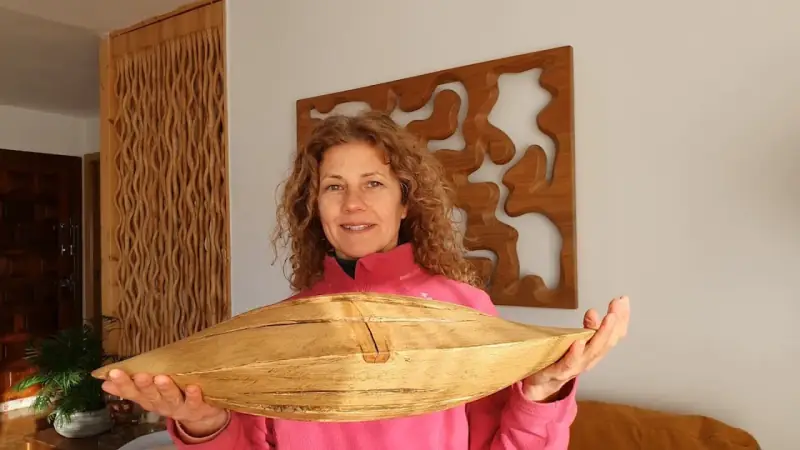 Sandra Krysiak sostiene la pieza de madera con forma de semilla que talla en el tutorial