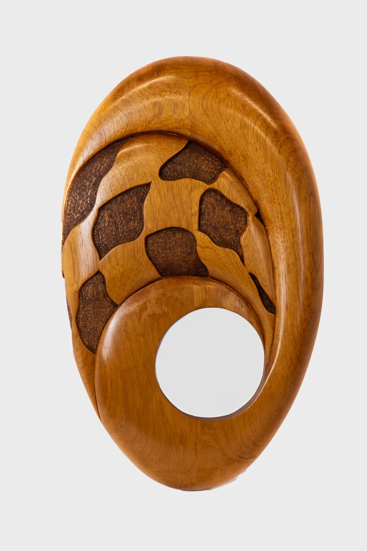 Talla ovalada de cedro con una espiral interior en forma de anillo abierto y un vacío circular en el centro